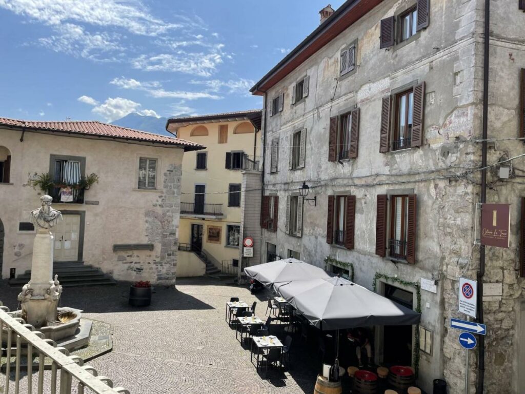 View of a historic square with outdoor dining near Palazzo Cinquecento, Lovere, presented by Fabula Home Rental